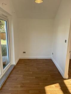 A bright, clean empty room with wooden flooring...