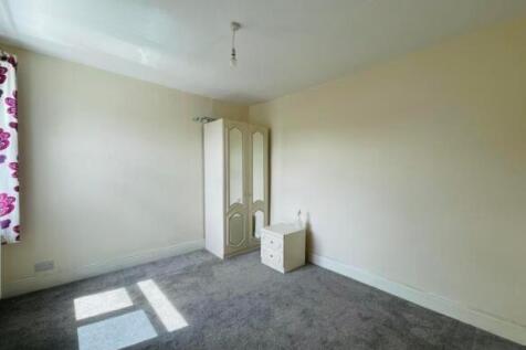 A bright double bedroom featuring a large windo...