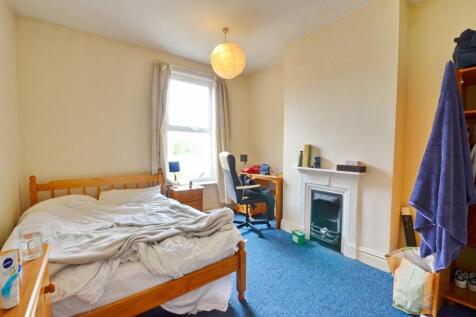 A cozy double bedroom featuring a wooden double...