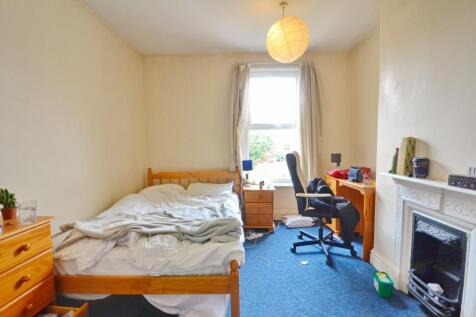 A cozy single bedroom featuring a comfortable b...