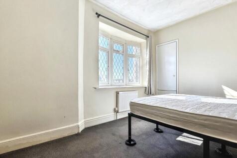 A bright double bedroom featuring a large windo...