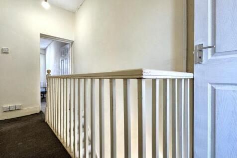 A bright and clean hallway featuring white wall...