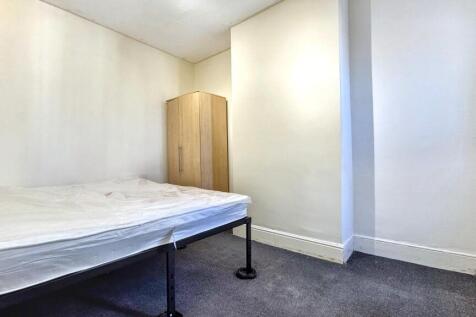A neat and simple single bedroom featuring a co...