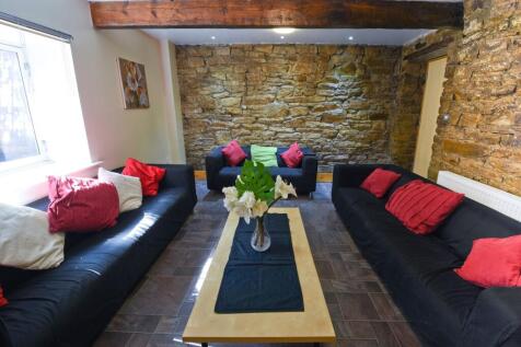 A cozy living room featuring exposed stone wall...