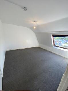 A simple, clean single bedroom featuring a larg...