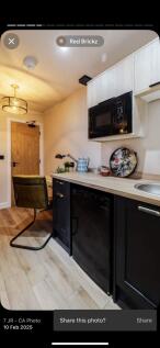 A modern kitchen area featuring sleek black and...