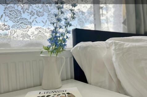 A serene bedroom corner featuring a neatly made...