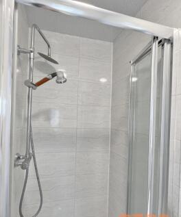 A modern bathroom shower area featuring a dual ...
