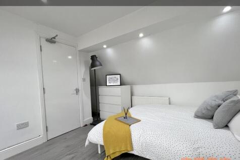 A cozy single bedroom featuring a neatly made b...