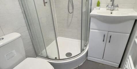 Modern bathroom featuring a curved glass shower...