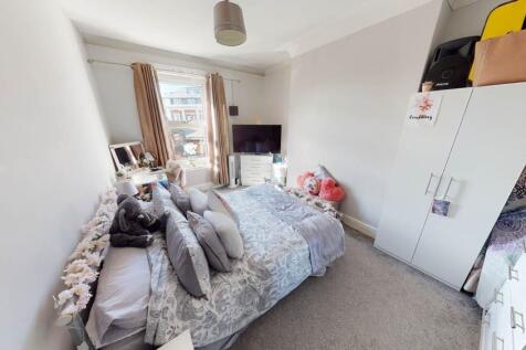 A cozy single bedroom featuring a comfortable b...