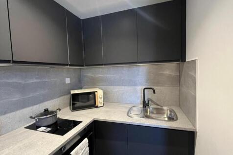 Modern kitchen featuring sleek black cabinetry ...