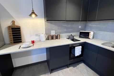 A modern kitchen featuring sleek black cabinetr...