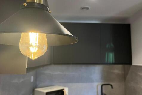Modern kitchen corner featuring sleek dark cabi...