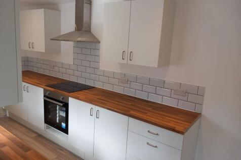 A modern kitchen featuring clean white cabinetr...