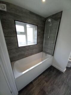 A modern bathroom suite featuring a clean white...