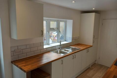 Bright and modern kitchen featuring clean woode...