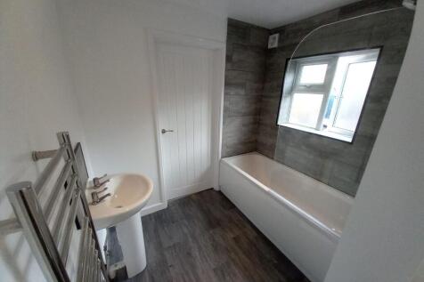 Modern bathroom featuring a clean white bathtub...