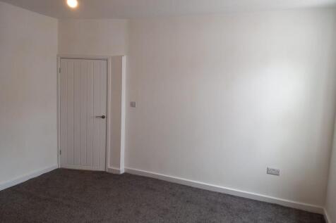 A clean and freshly painted single bedroom with...