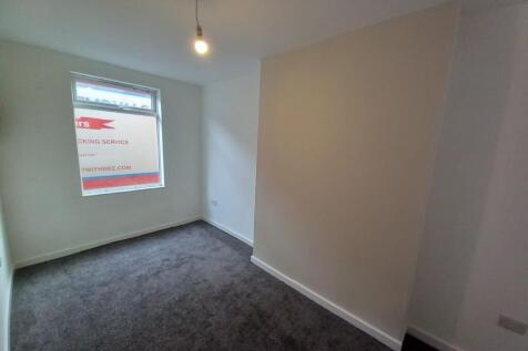 A neat and freshly painted small bedroom with d...
