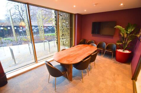 A modern communal workspace featuring a large w...