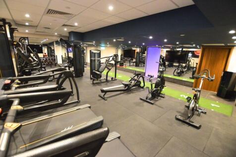 A modern, well-equipped gym featuring treadmill...