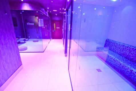 A modern communal lounge area with sleek glass ...