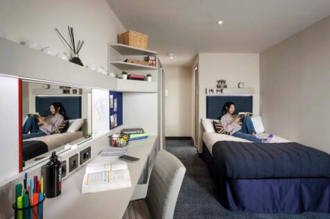 A well-organized single bedroom featuring a com...