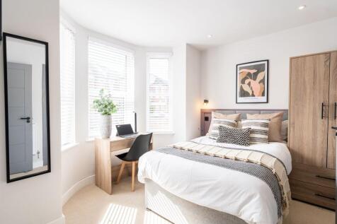 A bright and welcoming double bedroom featuring...
