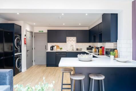 A modern kitchen featuring sleek dark cabinetry...