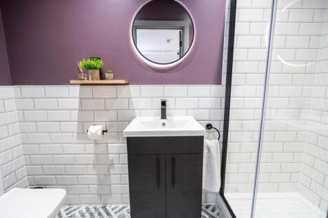 Stylish modern bathroom featuring sleek white s...