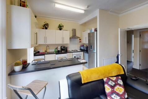 A modern kitchen area featuring white cabinetry...