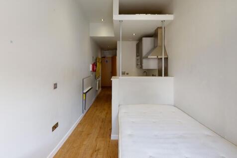 A compact single bedroom featuring a neat woode...