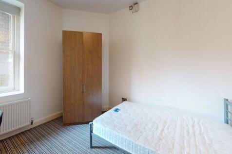 A bright and tidy single bedroom featuring a co...
