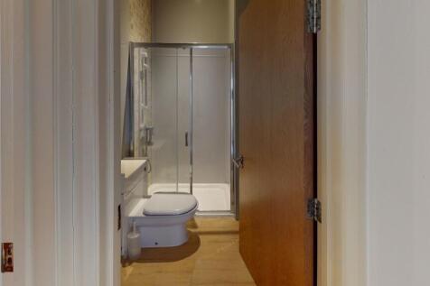 A neat and modern bathroom featuring a glass-en...