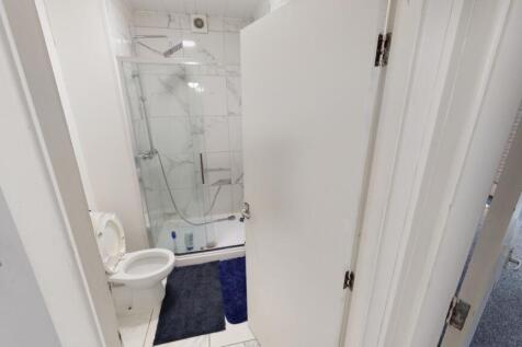 Bright and modern bathroom featuring a glass-en...