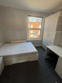 A bright double bedroom featuring a comfortable...