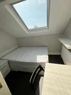 A bright double bedroom featuring a large skyli...