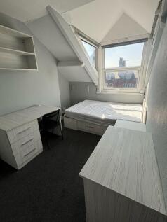Bright single bedroom featuring a large window ...