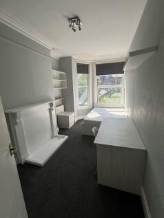 A cozy single bedroom featuring a large window ...