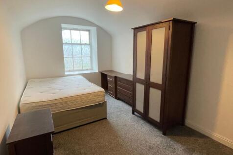 Bright double bedroom featuring a large window ...