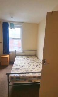 A tidy single bedroom featuring a metal bed fra...