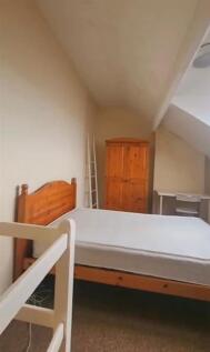 A neat and simple room with a wooden bed frame ...