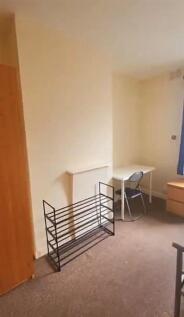 A simple room corner featuring a desk with a ch...