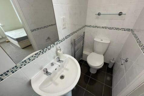 A clean and tidy small bathroom featuring white...