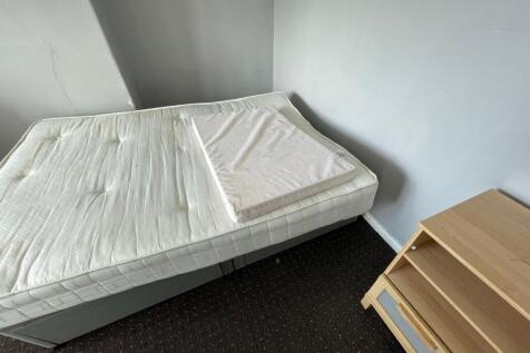 A simple single bedroom featuring a plain mattr...