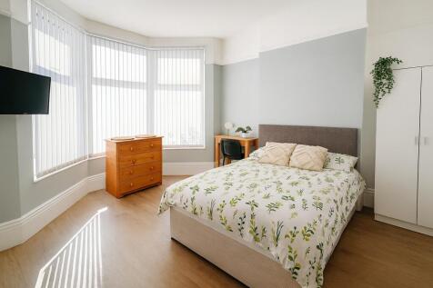 Bright and spacious master bedroom with a large...
