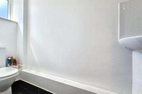 A clean, simple bathroom featuring a white bath...