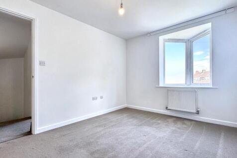Bright double bedroom featuring a large window ...