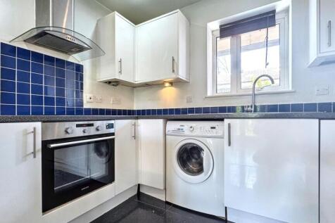 A modern kitchen featuring white cabinetry, a b...
